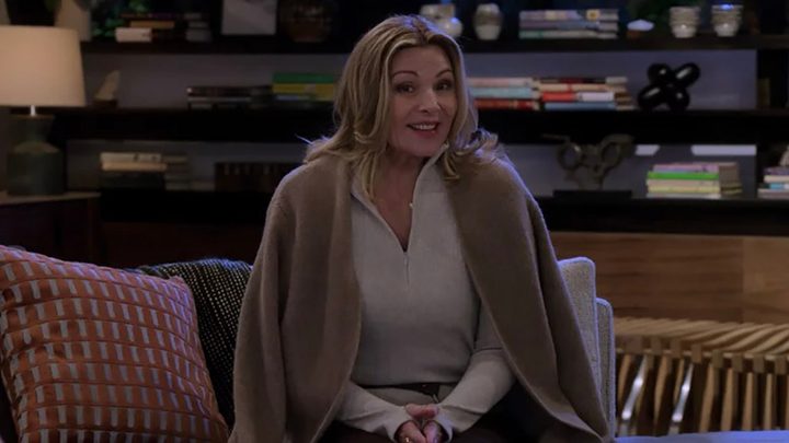 Kim Cattrall on a couch, a shawl over her shoulders mid sentence in a scene from How I Met Your Father.