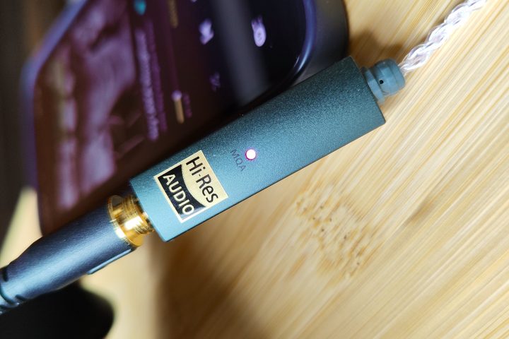 Ifi Go Link headphone DAC/amp displaying an LED indicator for the MQA format.