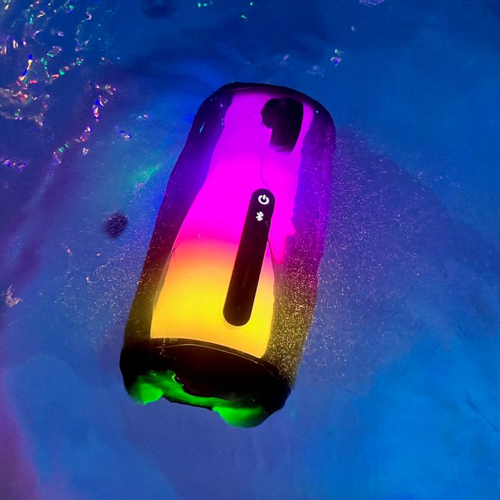 The JBL Pulse 5 Bluetooth speaker submerged in a hot tub.