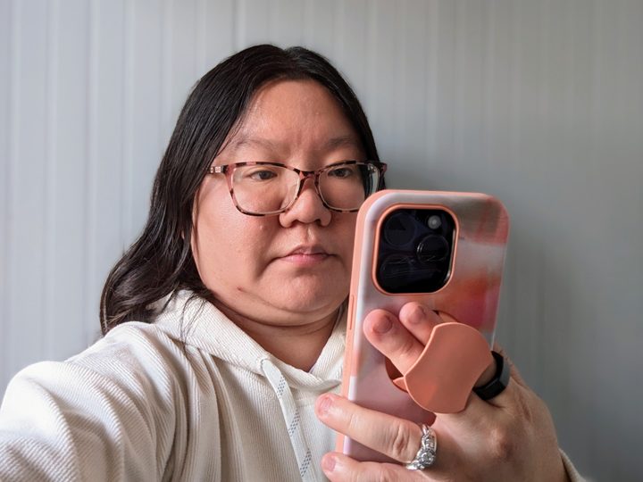 Christine holding her iPhone 14 Pro with OtterBox OtterGrip case