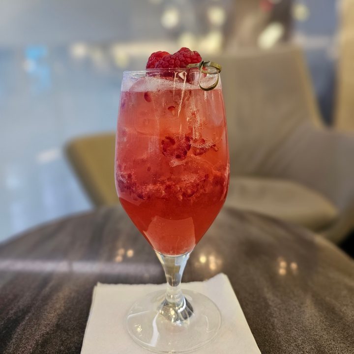 Galaxy S23 Ultra portrait mode photo of a raspberry drink on a table.