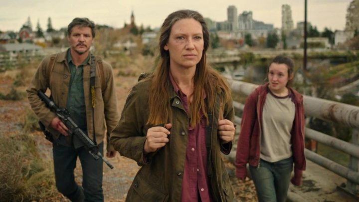 A woman walks ahead of a man and a girl in The Last of Us.