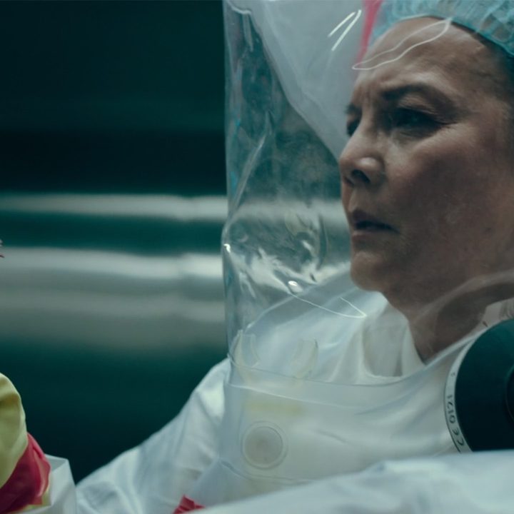 A scientist in a protective suit holds a small bundle of mycelia in a lab in The Last of Us for HBO.