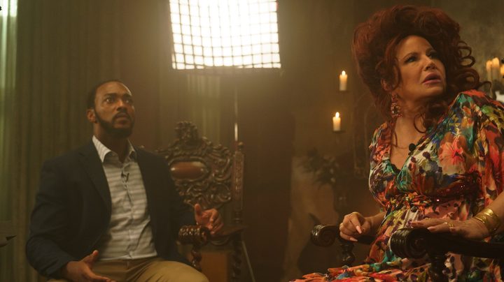Anthony Mackie and Jennifer Coolidge sit in chairs, looking astonished, in a scene from We Have A Ghost.