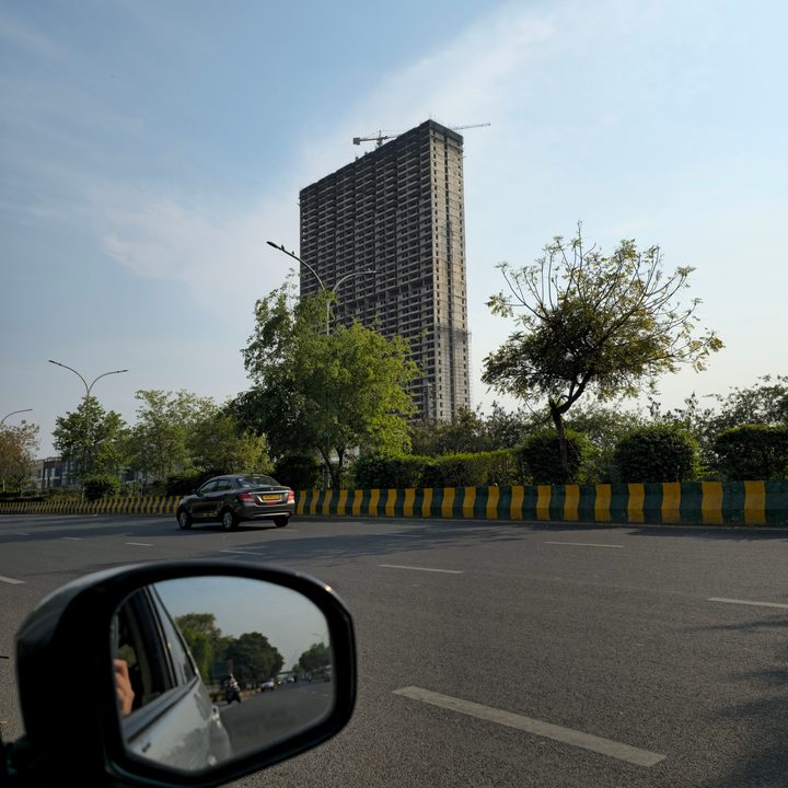 Multi-storey building under construction on the side of a road captured by Samsung Galaxy S23 Ultra.