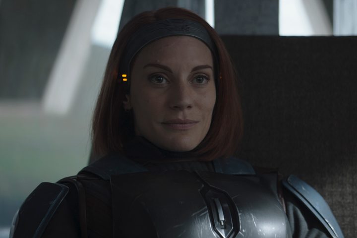 Bo-Katan smiles while sitting on her throne in The Mandalorian Season 3 Episode 1.