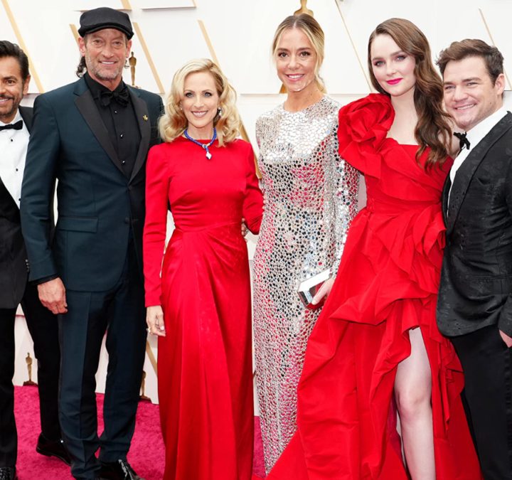 The cast of Coda stand on the Oscars red carpet.