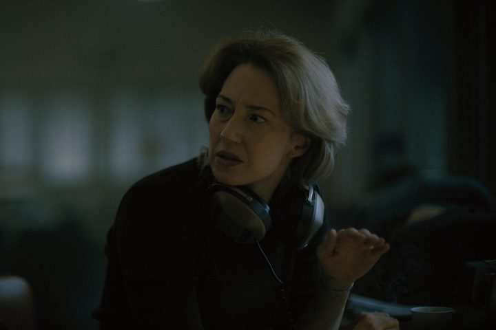 Carrie Coon wears a pair of headphones in Boston Strangler.