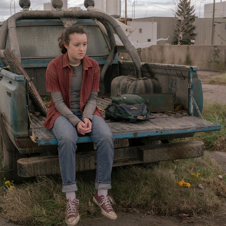 Ellie sits on a truck bed in The Last of Us Episode 9.