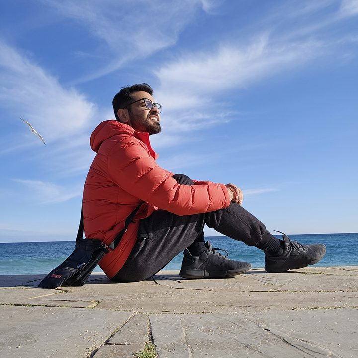 Prakhar Khanna sitting by the Costa Brava beach in Spain.