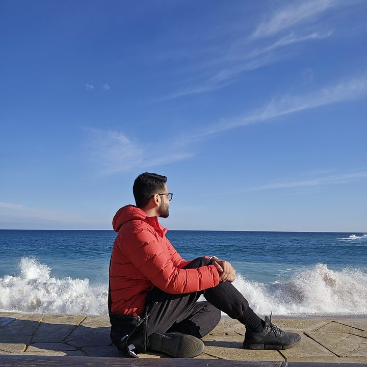 Prakhar Khanna sitting by the Costa Brava beach.