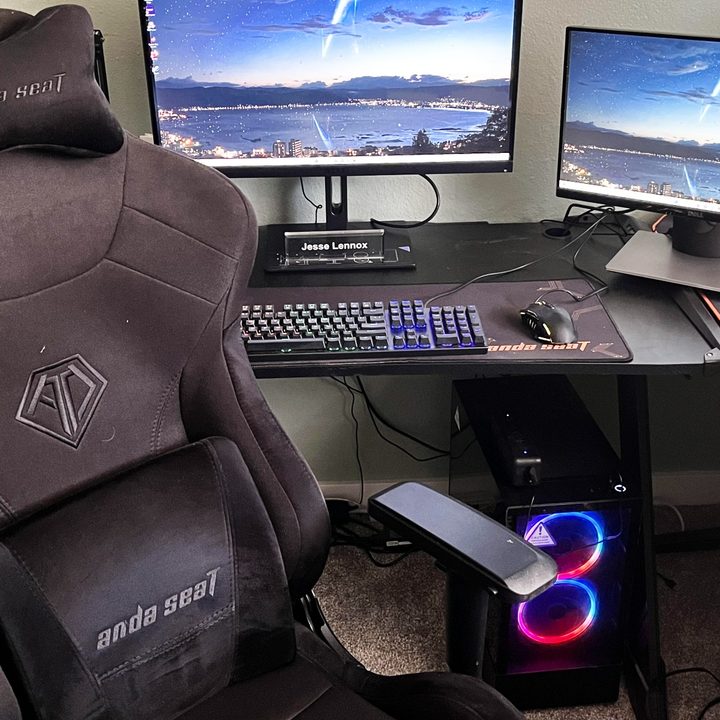 A PC gaming desktop setup with two monitors and a gaming chair.