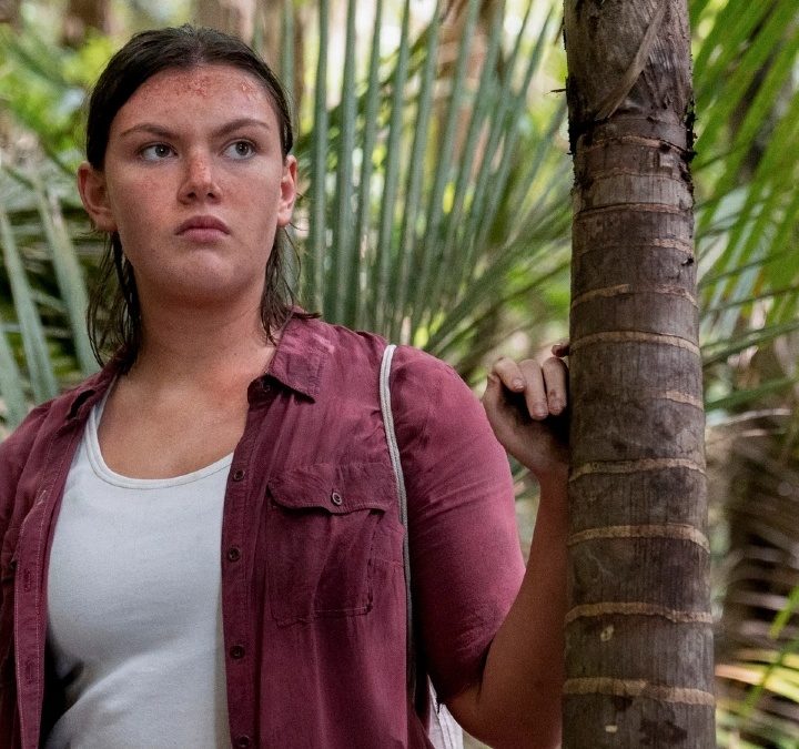 Shannon Berry as Dot Campbell leaning on a tree in The Wilds.