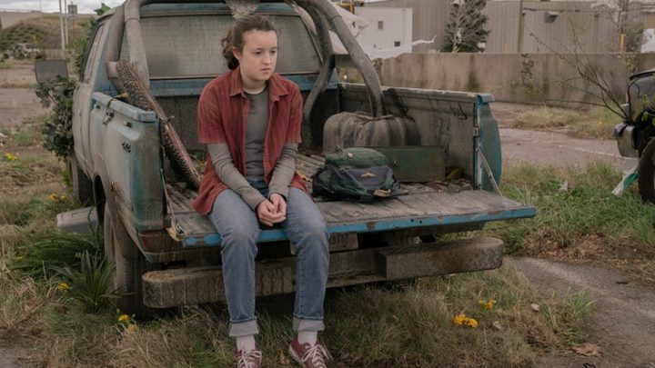 Ellie sits on a truck in The Last of Us.