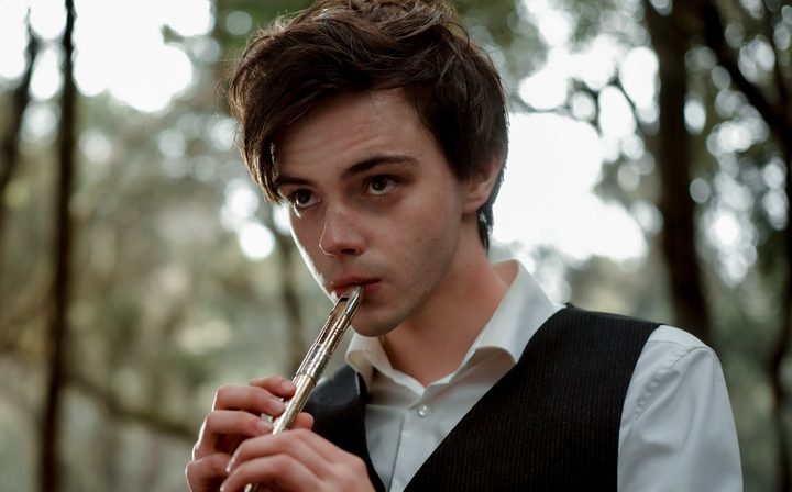 A boy plays a flute in The Magic Flute.