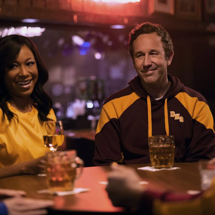 A couple sits next to each other at a bar in The Big Door Prize.