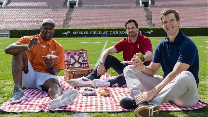 Three men sit down and have a picnic in Eli's Places.