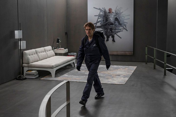 Willem Dafoe walks past a photograph in Inside.
