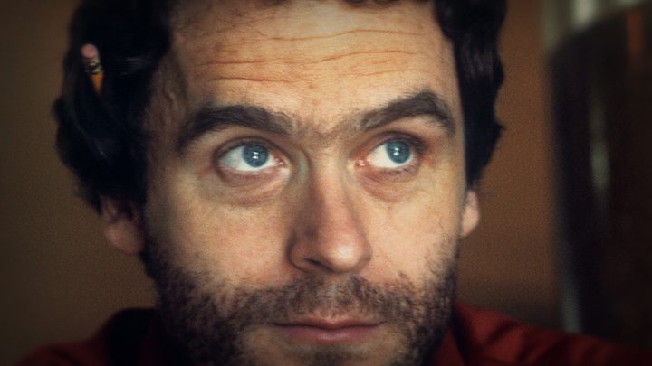 A close up of Ted Bundy looking upwards, a pencil on his ear in a scene from Conversations With a Killer: The Ted Bundy Tapes on Netflix.