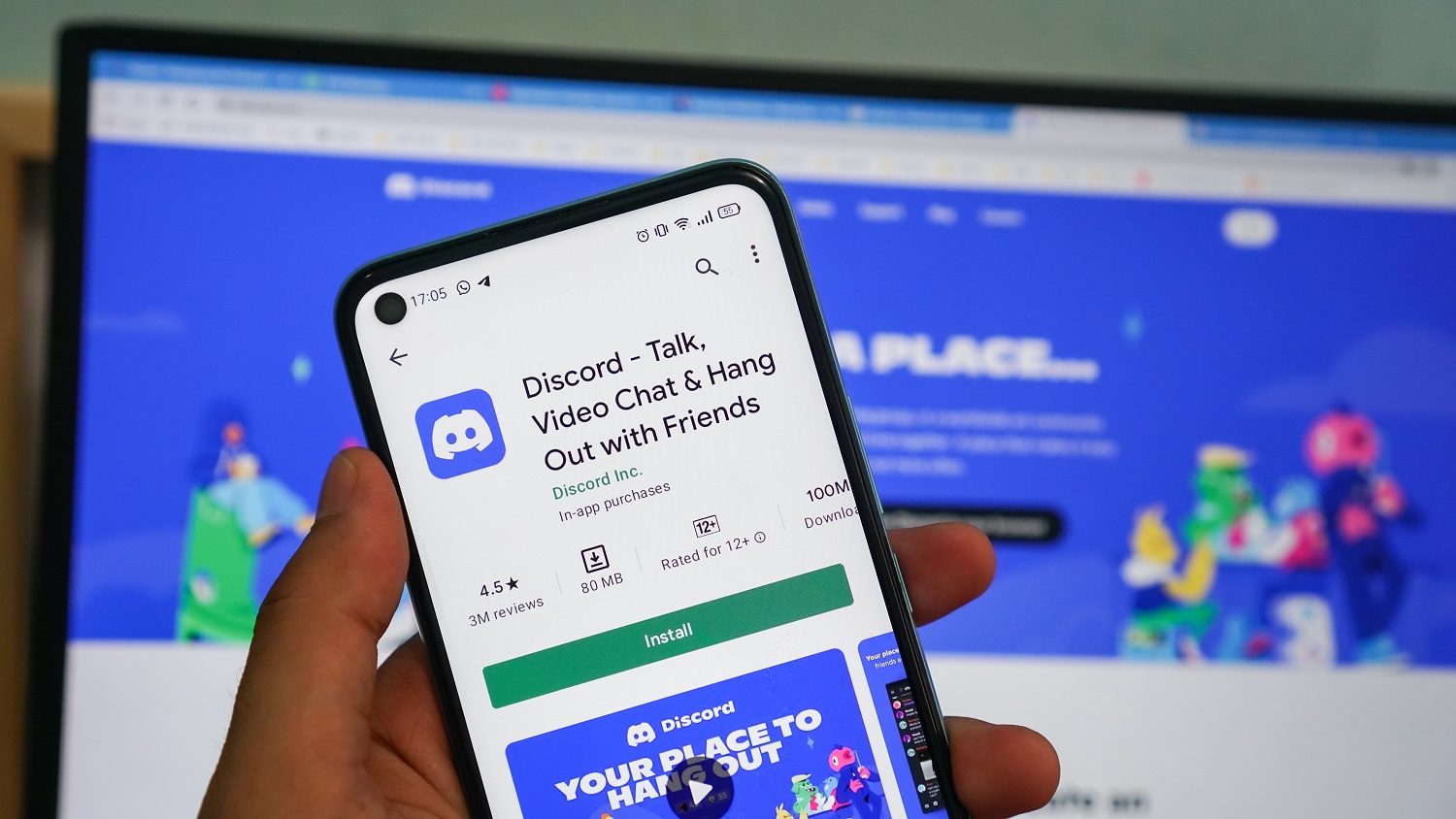 A person holding a smartphone with the Discord app displayed.