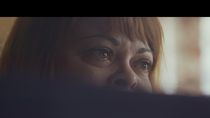 A woman's eyes between two black bars in a scene from Don't F**k With Cats on Netflix.