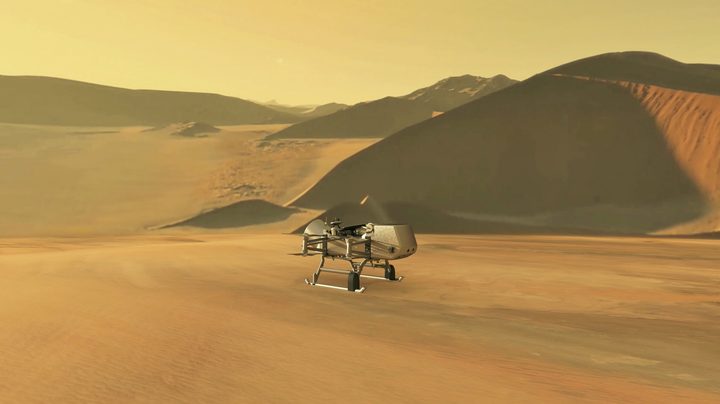 This illustration shows NASA’s Dragonfly rotorcraft-lander approaching a site on Saturn’s exotic moon, Titan. Taking advantage of Titan’s dense atmosphere and low gravity, Dragonfly will explore dozens of locations across the icy world, sampling and measuring the compositions of Titan's organic surface materials to characterize the habitability of Titan’s environment and investigate the progression of prebiotic chemistry.