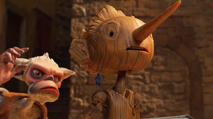 The wooden toy Pinocchio, a creature behind him in a scene from Guillermo del Toro's Pinocchio.