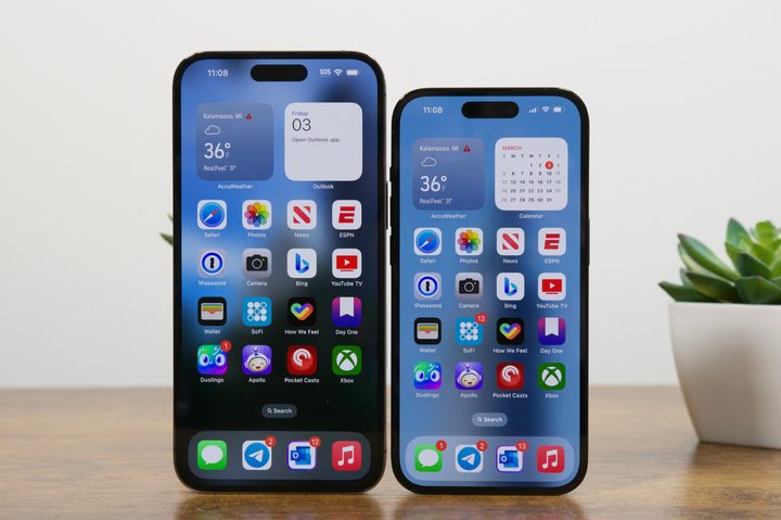 An iPhone 14 Pro Max and iPhone 14 Pro standing upright on a desk.
