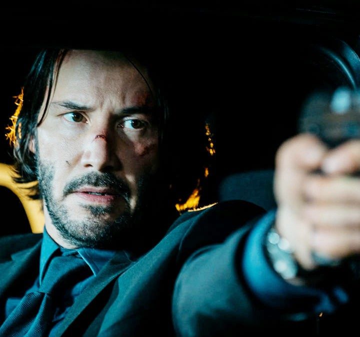 Keanu Reeves points a gun in John Wick.