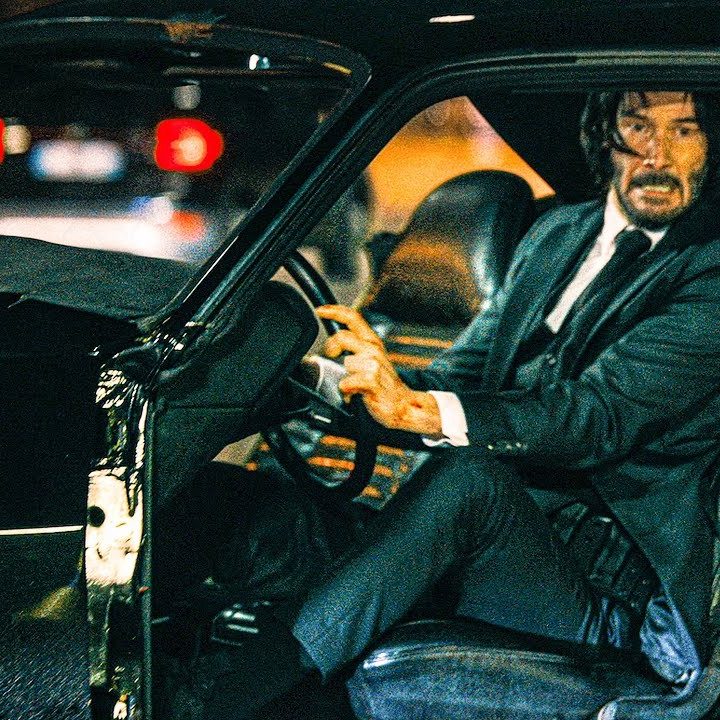 John Wick drives a car in John Wick 4.