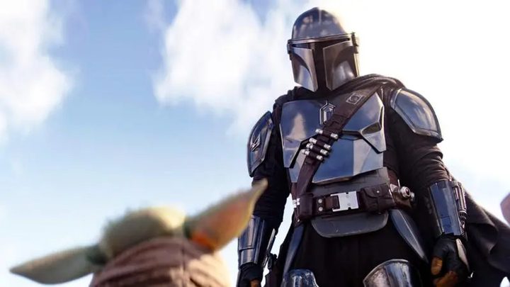 Din looks down at Grogu in The Mandalorian.