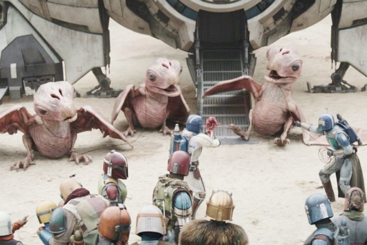 Din is surrounded by aliens in The Mandalorian.