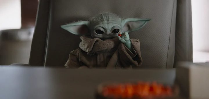 Grogu holds up a red jewel in The Mandalorian.