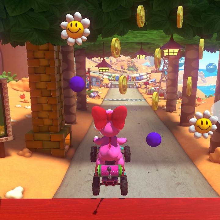 Birdo rides through a goal ring in Mario Kart 8 Deluxe's Yoshi course.