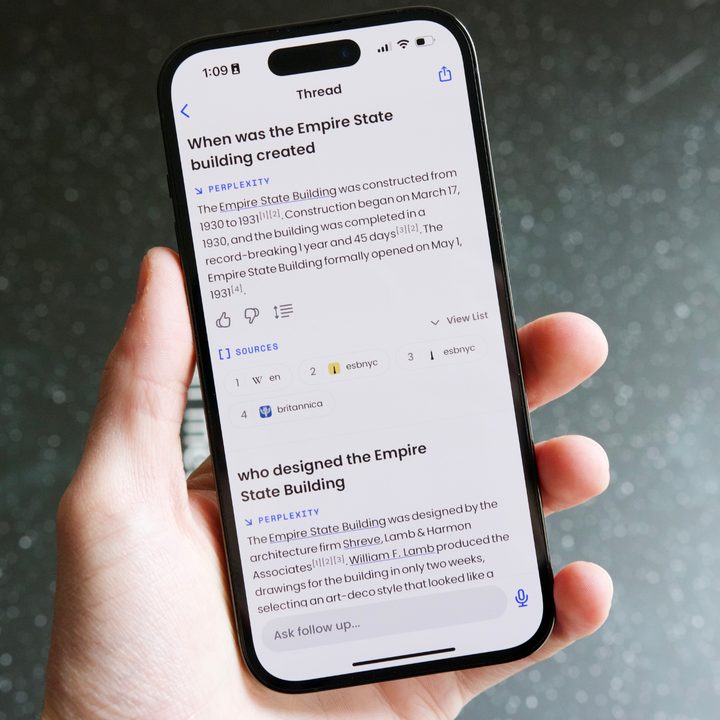 Someone holding an iPhone 14 Pro, with Perplexity AI running on it.