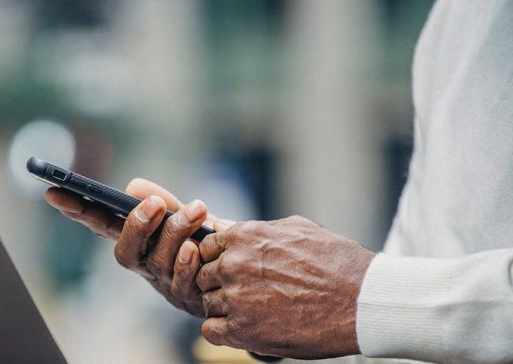 An elderly person holding a phone.
