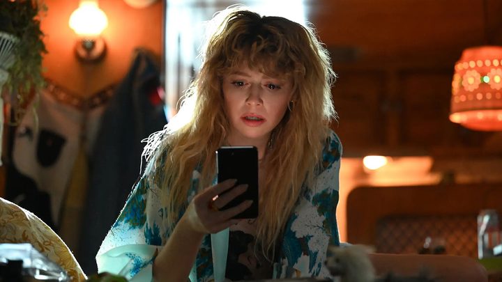 Charlie on the phone, looking shocked in a scene from Poker Face on Peacock.
