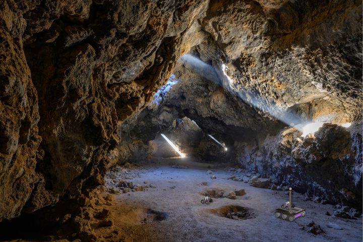 In this artist's impression of the breadcrumb scenario, autonomous rovers can be seen exploring a lava tube after being deployed by a mother rover that remains at the entrance to maintain contact with an orbiter or a blimp.