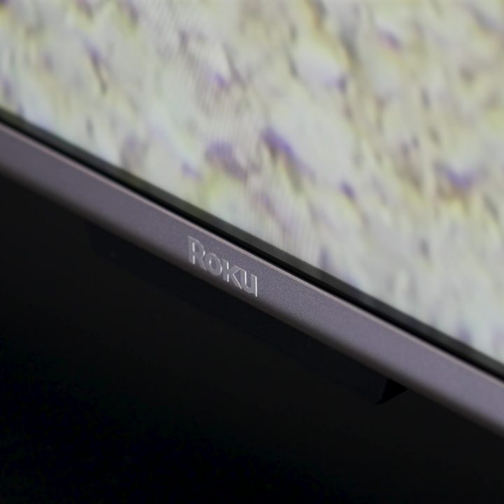 Closeup of Roku logo on the bottom bezel of a Roku Plus Series TV.