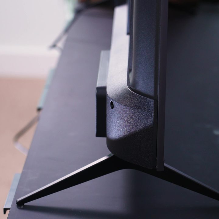 The feet of a Roku Plus Series TV on a media stand.
