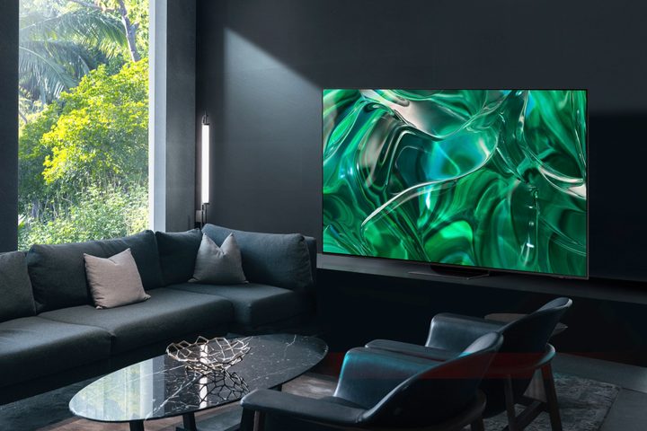 Samsung 2023 S95C QD-OLED TV seen in a brightly-lit room near windows.