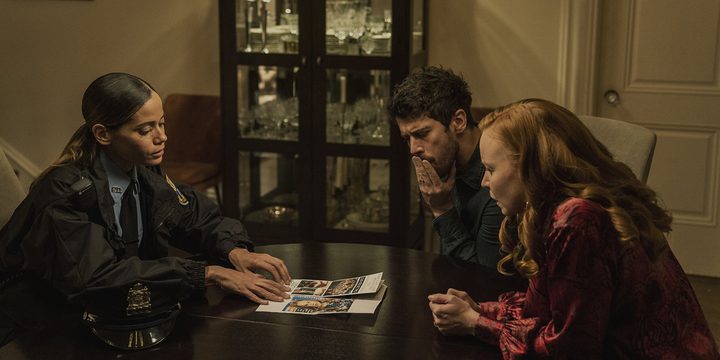 Officer Reyes sits at the table with Sean and Dorothy in a scene from Servant.
