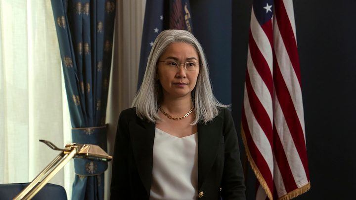 Hong Chau as Diane in The Night Agent, standing in a White House office in front of an American flag.