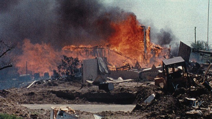 The Mount Carmel compound engulfed in flames in historical footage from Waco: American Apocalypse.
