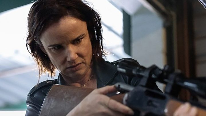 Nat from Yellowjackets holding a gun and aiming it at someone.