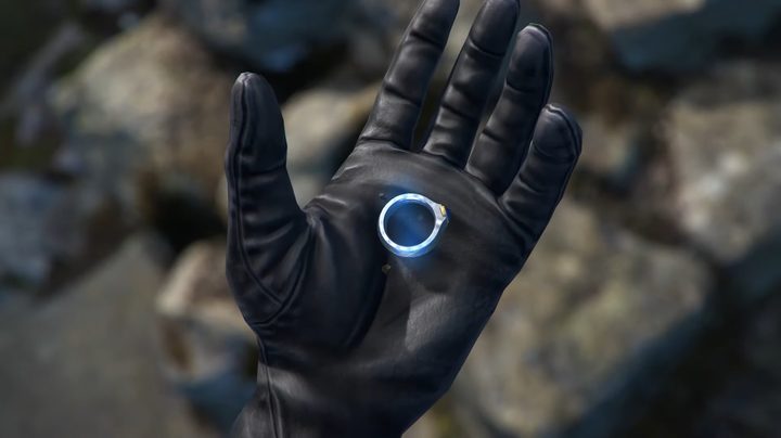 A gloved hand holds a ring.