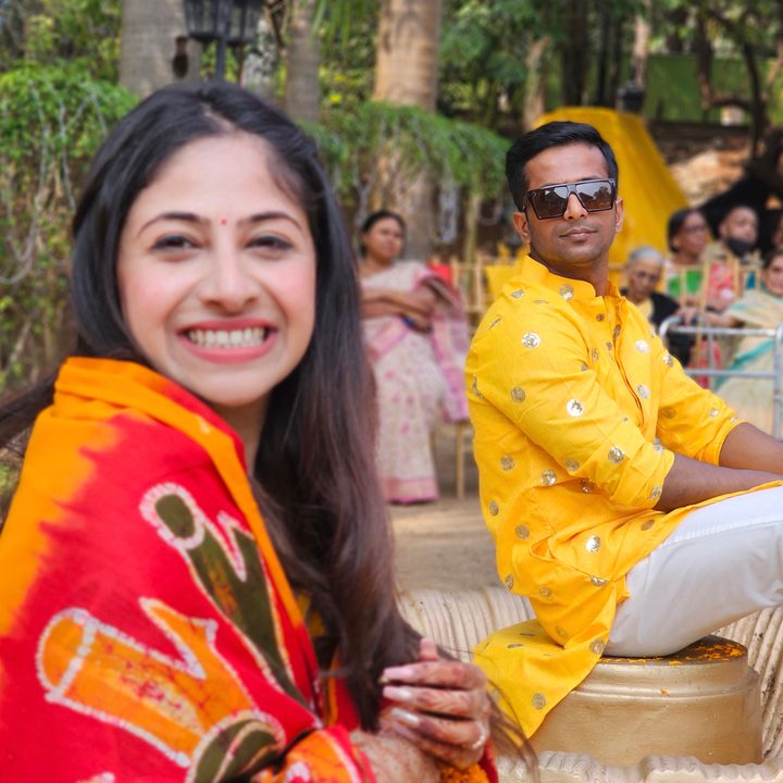 Focus on Indian groom and Indian bride out of focus with attendees of an Indian wedding in background captured with the Samsung Galaxy S23 Ultra’s 3x telephoto portrait mode camera.