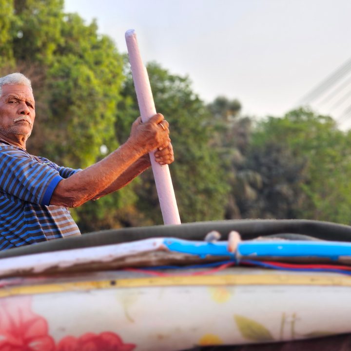 Aged oarsman rowing a wooden boat captured with the Samsung Galaxy S23 Ultra’s 3x telephoto portrait mode camera.