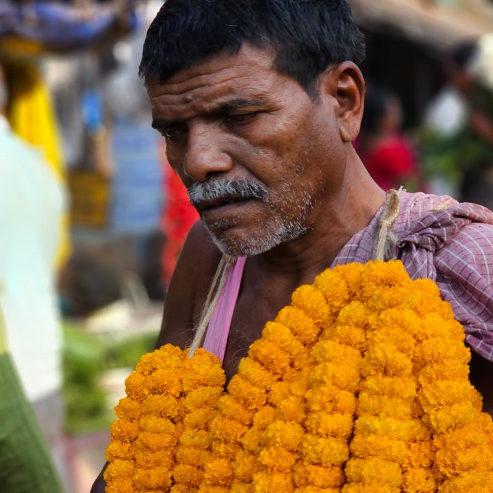 Flower vendor with marigold garlands around his neck captured with the Samsung Galaxy S23 Ultra’s 3x telephoto portrait mode camera.