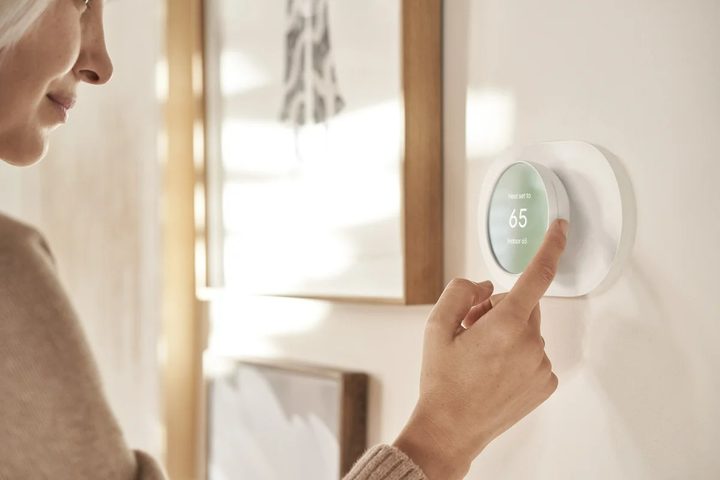 A person controlling the Nest Thermostat.